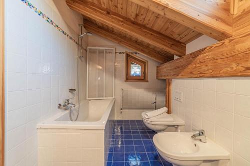 La salle de bains est pourvue de 2 toilettes, d'un lavabo et d'une baignoire. dans l'établissement Chalet Dolomites Heart, à Feder