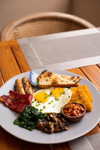 a plate of breakfast food with eggs bacon and beans at The Daha Luxury Villas in Seminyak