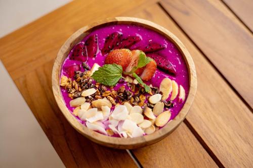 a bowl of food with fruit and nuts on a wooden table at The Daha Luxury Villas in Seminyak