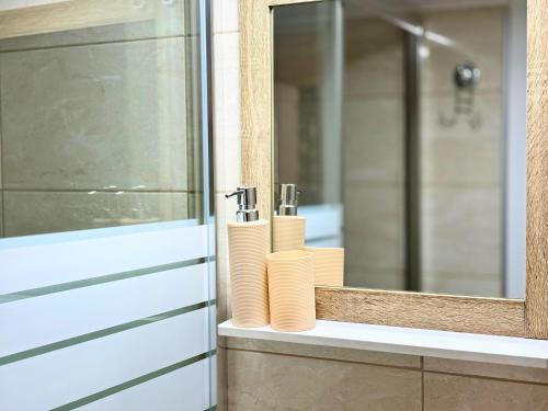 ein Badezimmer mit Spiegel und drei Rollen Toilettenpapier in der Unterkunft City Charm Apartments 1A in Warna