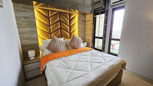 a bedroom with a bed with an orange and white comforter at Cozy Apartment with Sea View - One Residence in Pulau Sembakau Kecil