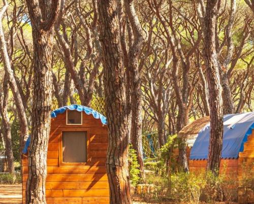 a wooden cabin in the middle of trees at Gitavillage Le Marze in Marina di Grosseto