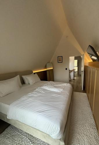 a bedroom with a large white bed in a attic at Chalet NATURTRAUM in Runkel