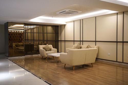 a waiting room with couches and a table and chairs at HARRIS Hotel Samarinda in Samarinda