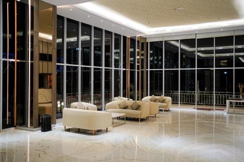a lobby with couches and chairs in a building at HARRIS Hotel Samarinda in Samarinda