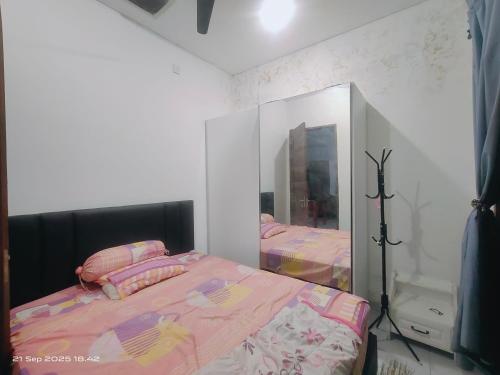 a bedroom with two beds and a mirror at Ubung Little House Denpasar in Sempidi
