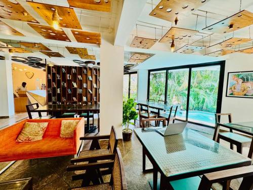 a living room with a couch and a table with a laptop at HALF Hotel, Calangute in Calangute