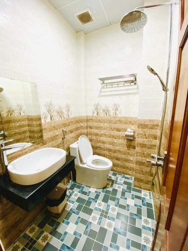 a bathroom with a toilet and a sink and a tub at Khách Sạn Bình Nguyên Đà Lạt in Da Lat