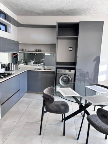 a kitchen with a glass table and two chairs at The Aurelian Apartment in Johannesburg