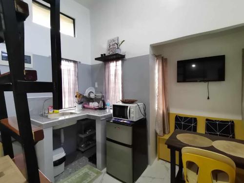 a small kitchen with a table and a microwave at Villa Kendra in Moalboal