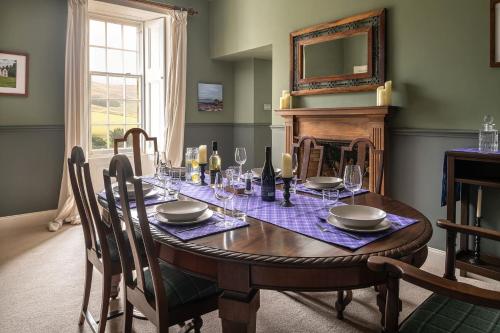 a dining room with a table and a fireplace at Quarter House in Broughton