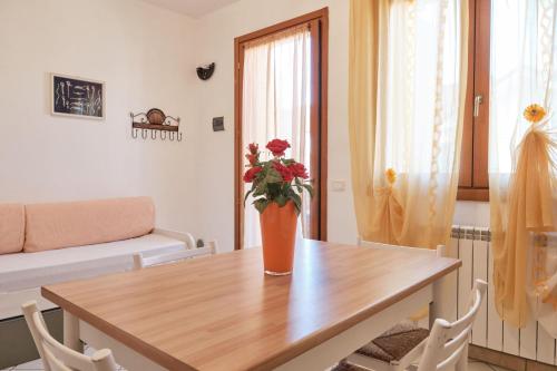 a table with a vase of flowers on top of it at Sunny holiday flat-Beahost in Rosapineta