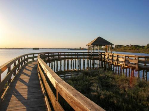 a dock with chairs and a gazebo on the water at Sunny holiday flat-Beahost in Rosapineta