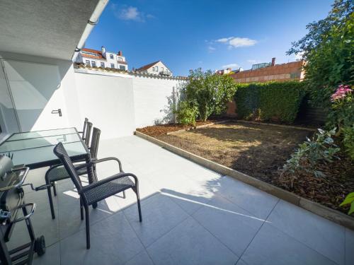 a patio with a table and chairs and a garden at ImmoStay- Neustadt Apartments, TV & WiFi in Bremen