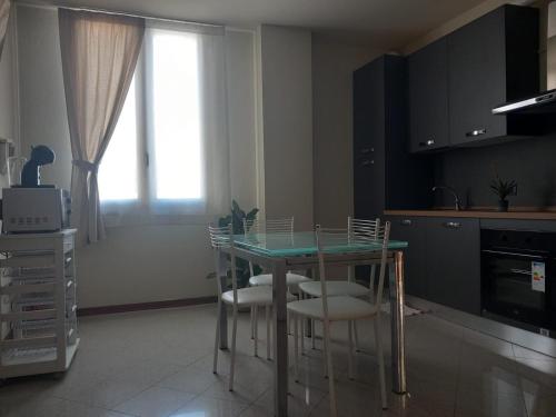 a kitchen with a table with chairs and a window at La Casa di Leo in Stabbia