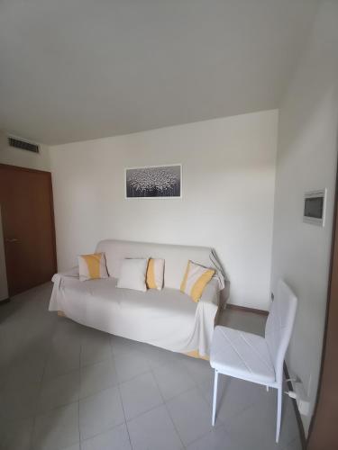 a white bed with pillows and a chair in a room at La Casa di Leo in Stabbia