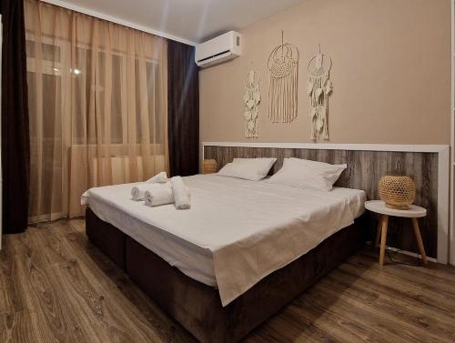 Un dormitorio con una cama grande con sábanas blancas. en къща за гости Рока, en Mineralni Bani