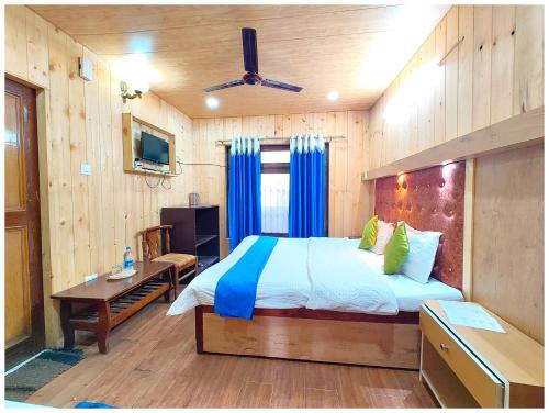 a bedroom with a large bed and a desk with at Lake View Hotel Chinar Mall Road Nainital - Near NAINA DEVI TEMPLE & NAINI LAKE - FREE WI-FI AND ROOM SERVICE AVAILABLE - PREMIUM HOTEL IN NAINITAL in Nainital