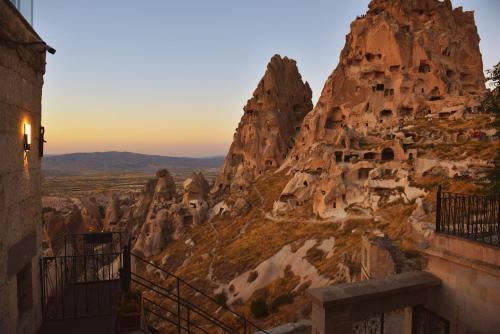 a view of a mountain with dwellings on it at Caldera Cave Hotel in Uchisar