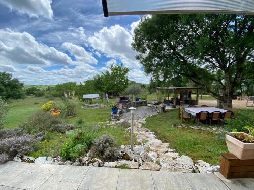 a garden with a picnic table and a gazebo at Oasis Graine de Joie in Cabrerets