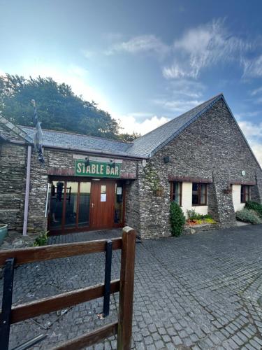 Un pequeño edificio de piedra con una barra de batidos encima. en 61, Stowford Gardens, en Combe Martin