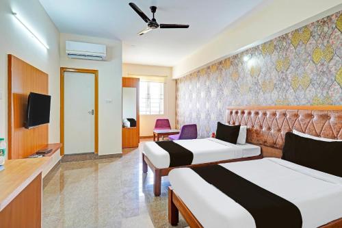 a hotel room with two beds and a tv at Hotel Golden Prime in New Delhi