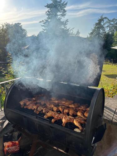 a grill with lots of meat cooking on it at Lindeth Howe in Bowness-on-Windermere