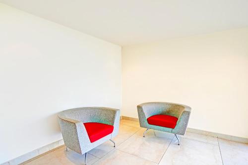 two chairs with red seats in an empty room at Hotel Golden Prime in New Delhi