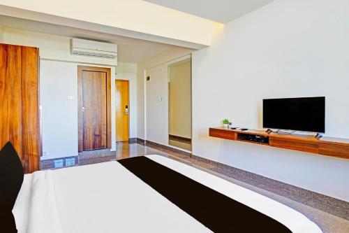 a hotel room with a bed and a flat screen tv at Hotel Golden Prime in New Delhi