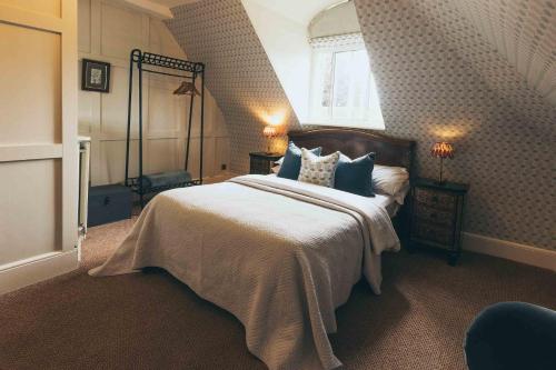 a bedroom with a large bed with blue pillows at Rowton Castle in Shrewsbury
