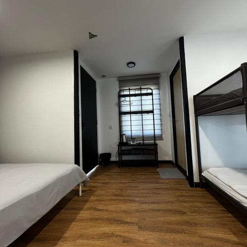 an empty room with two beds and a window at dChamp Retreat in Changlun