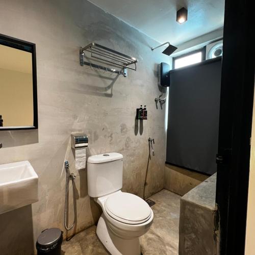a bathroom with a toilet and a sink and a mirror at dChamp Retreat in Changlun