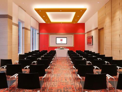 a large room with a row of chairs and a screen at ibis Coimbatore City Centre - An Accor Brand in Coimbatore