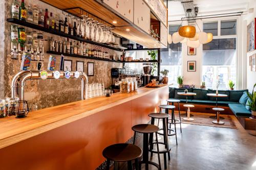a bar with stools in front of a counter at Will & Tate City Stay in The Hague