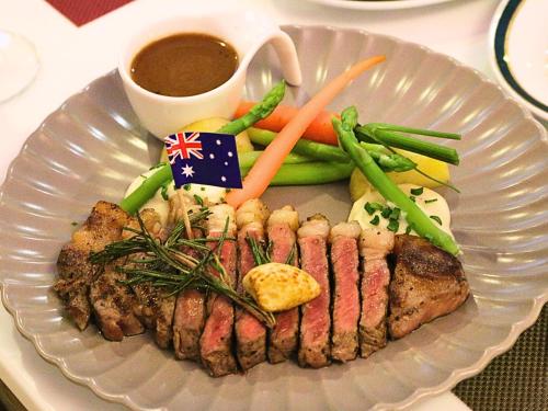 a plate of meat and vegetables with a cup of coffee at Sima Thani Hotel in Nakhon Ratchasima