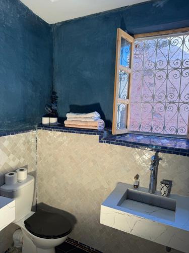 un bagno con wc e finestra di Riad Sarsar Dar dmana a Marrakech