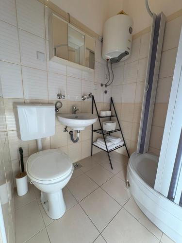 a bathroom with a toilet and a sink and a tub at Stari Bar Apartments in Stari Bar