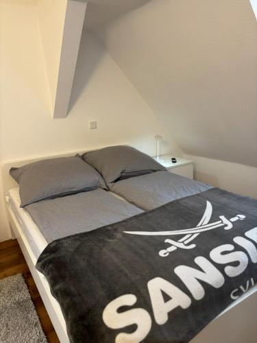 a bed with a black and white blanket on it at Ferienwohnung Mitten drin Bad Arolsen in Bad Arolsen