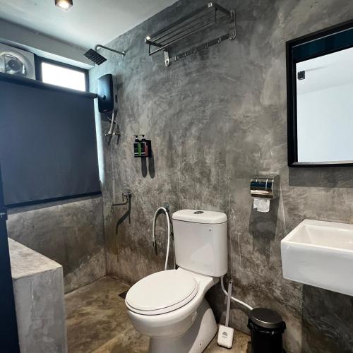 a bathroom with a toilet and a sink at dChamp Retreat in Changlun