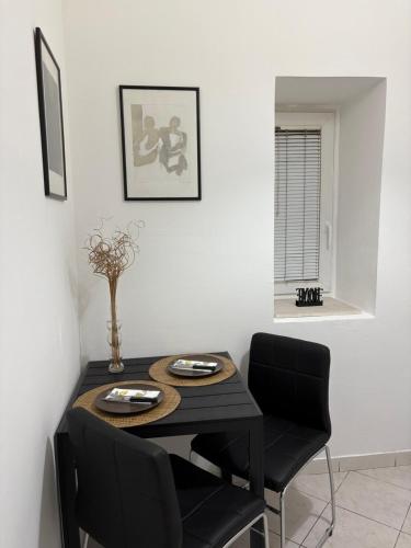 a dining room with a black table and chairs at Stari Bar Apartments in Stari Bar