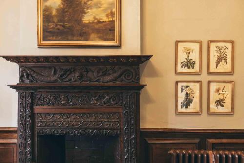 a fireplace in a room with pictures on the wall at Rowton Castle in Shrewsbury