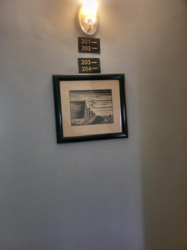 a picture hanging on a wall with a clock on it at TEM Palace Hôtel in Yaoundé