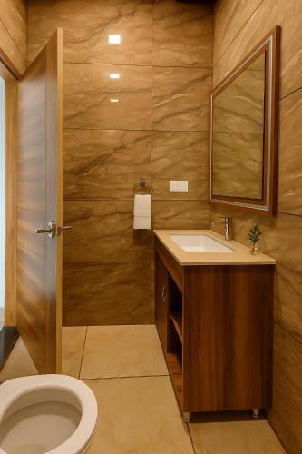 a bathroom with a toilet and a sink and a mirror at Mayur Resort in Mathura