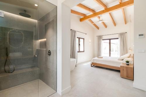 a bedroom with a bed and a shower and a tub at Villa Olivo in Ses Salines