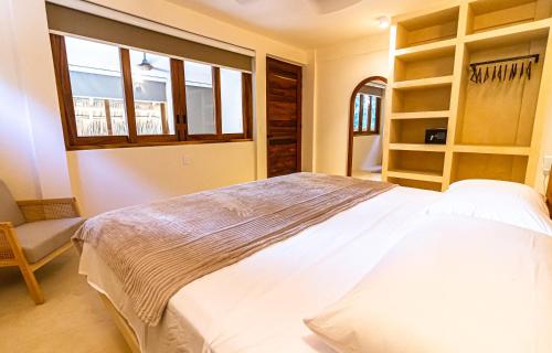 a bedroom with a large white bed and a window at 2 Room Loft, Kitchen, Garden in Mazunte