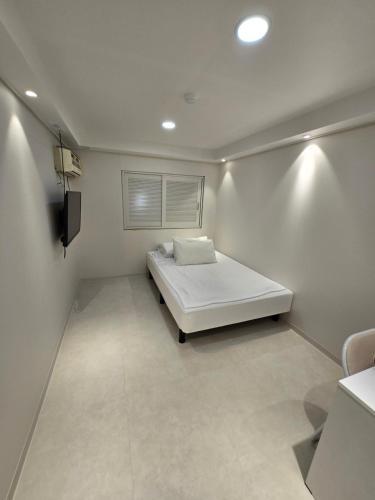 a small bedroom with a bed and a television at Han River KS Stay in Seoul
