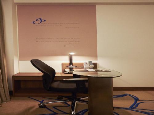 an office with a table and chairs in front of a board at Mercure Chennai Sriperumbudur in Sriperumbudur