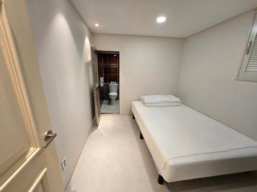 a small room with a bed and a toilet at Han River KS Stay in Seoul