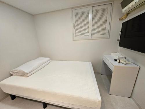 a small room with a bed and a flat screen tv at Han River KS Stay in Seoul
