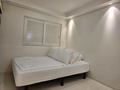 a white couch in a room with a window at Han River KS Stay in Seoul